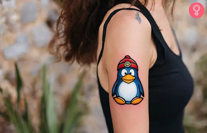 Club penguin tattoo on the upper arm