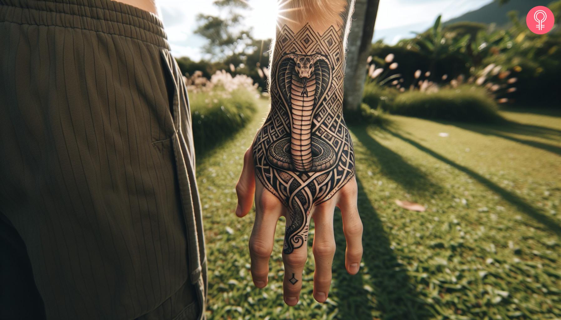 A geometric cobra tattoo on the back of a man’s hand