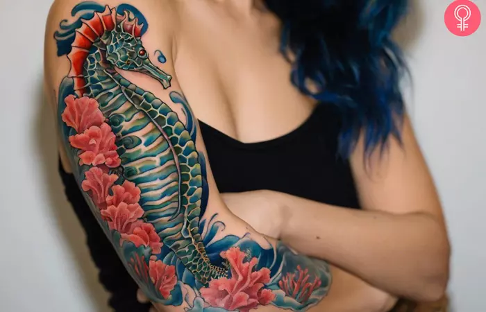 A woman with a colorful seahorse tattoo on her upper arm