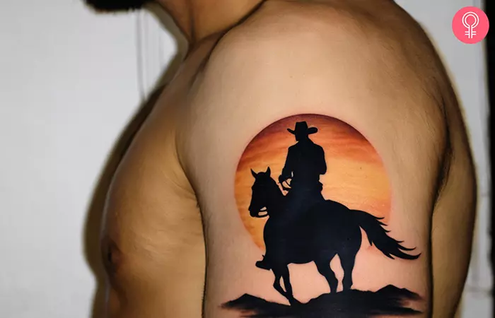 Cowboy silhouette tattoo on the upper arm