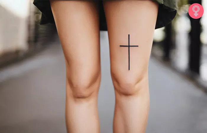 A cross above knee tattoo