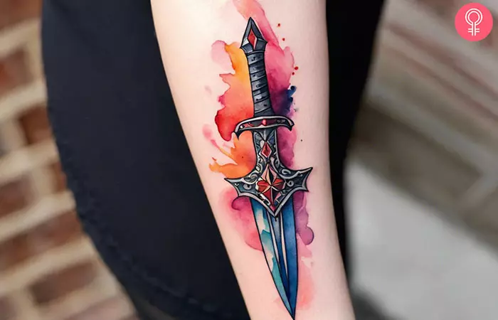 A woman with a dagger tattoo on her forearm