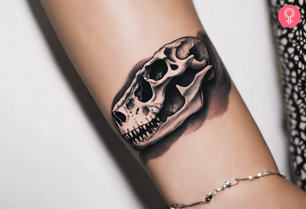 A woman with a dinosaur skull tattoo on her wrist