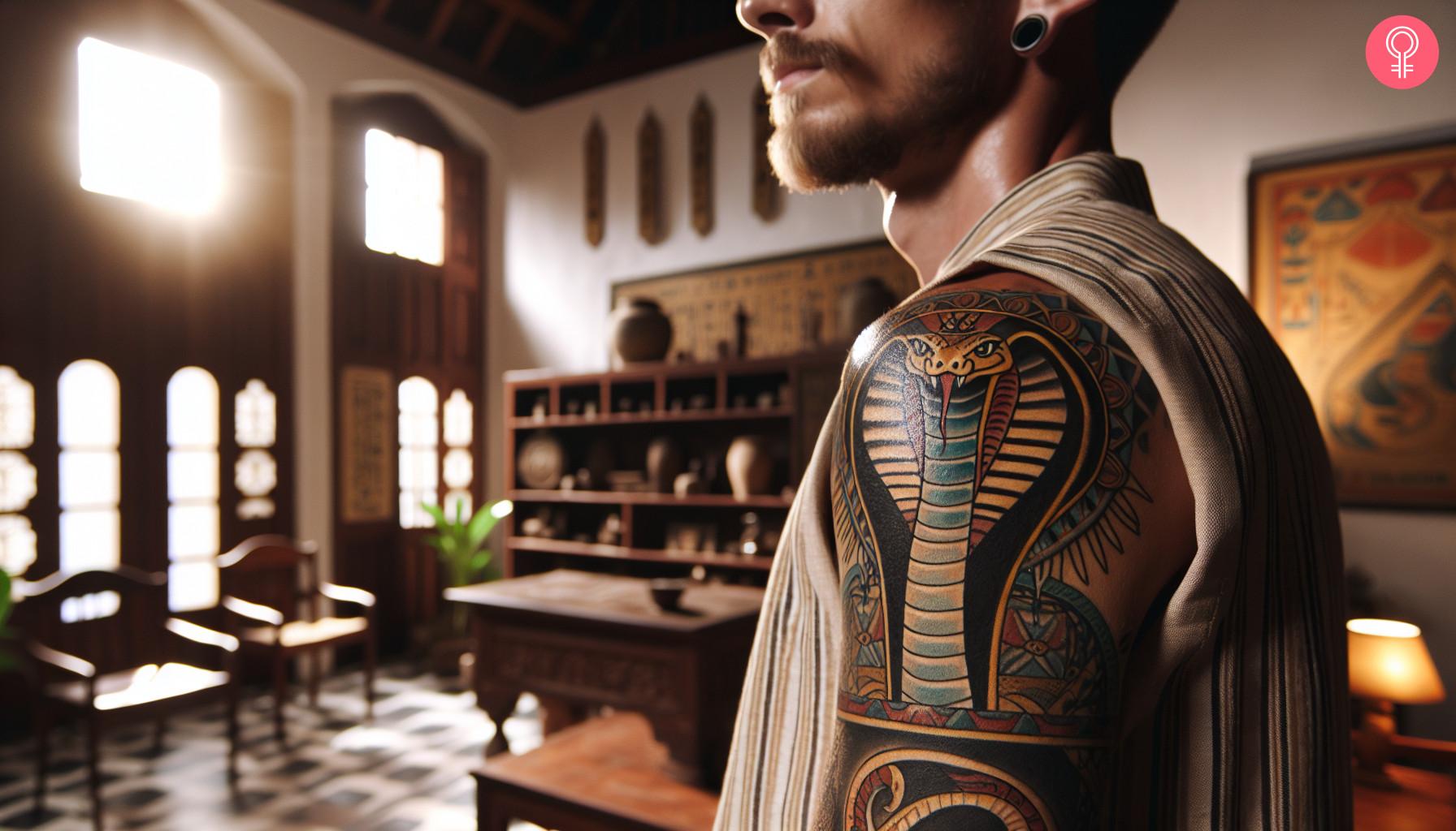 A vibrant cobra tattoo inspired by Egyptian art on a man’s upper arm