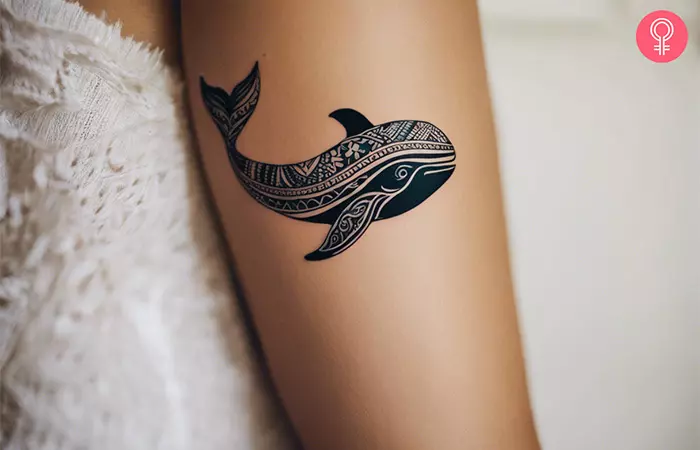 Ethnic whale tattoo on the upper arm
