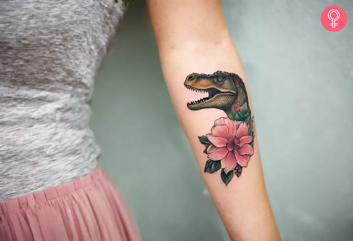 A woman with a dinosaur and flower tattoo on her arm