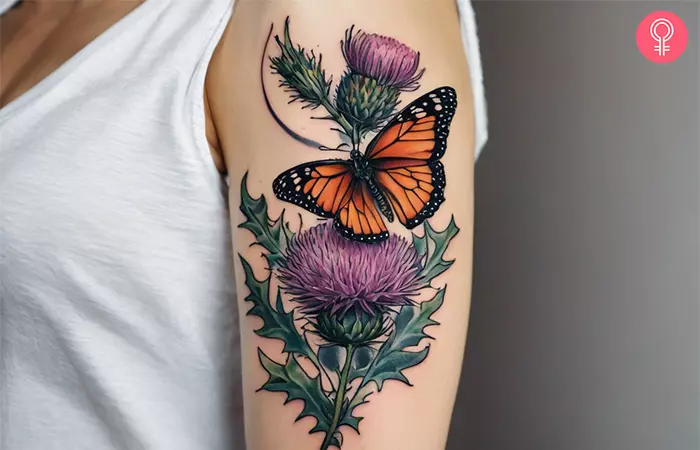 Feminine Scottish thistle tattoo on the upper arm