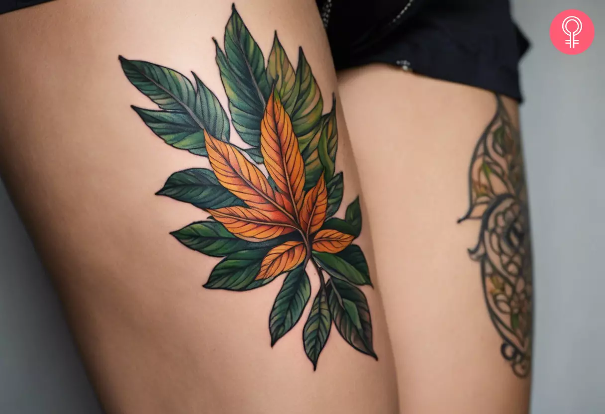 Fine line leaf tattoo on a woman’s upper thigh