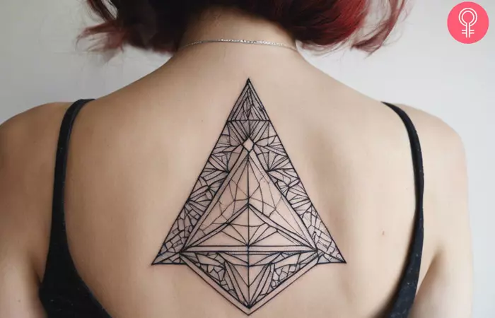 geometric dotwork tattoo on a woman’s upper back