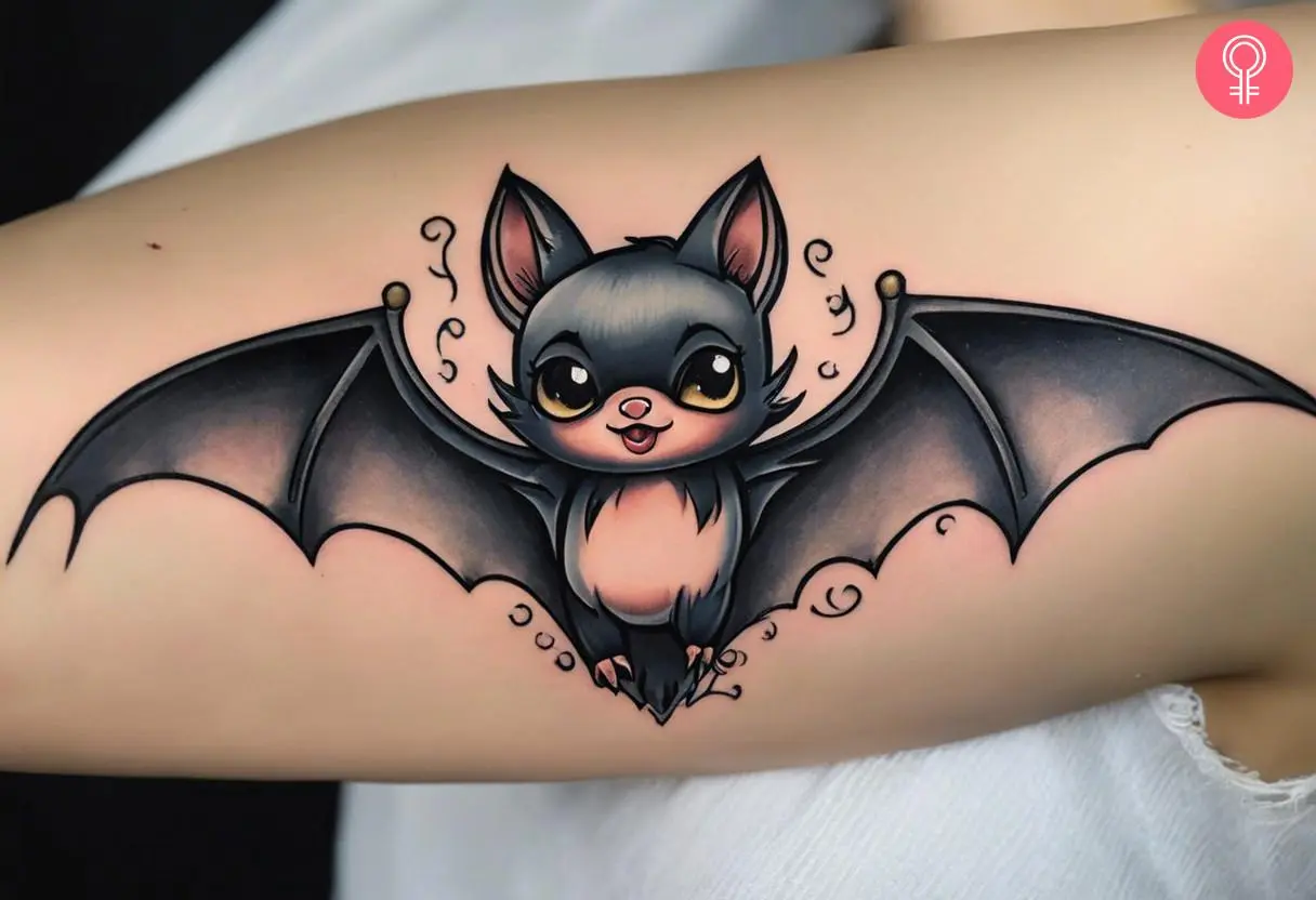 Girly bat tattoo on the arm of a woman