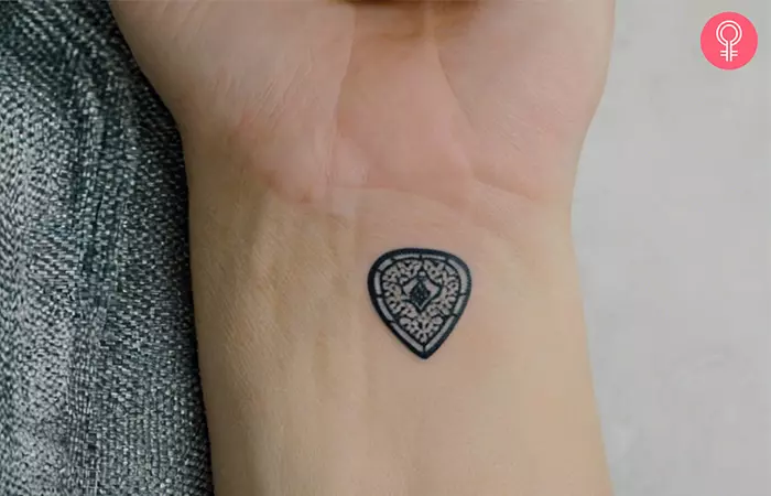 Guitar pick tattoo on the wrist