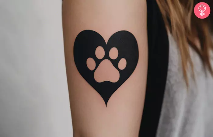 A heart paw print tattoo on the upper arm