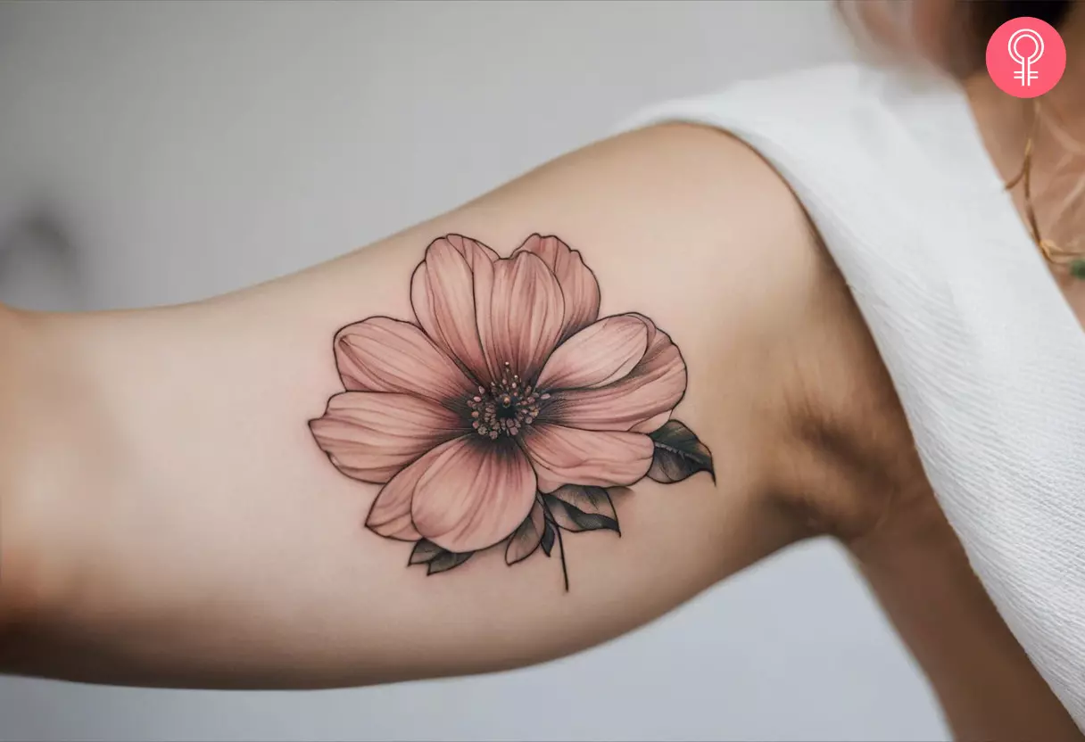 A pink flower tattoo on the inner bicep