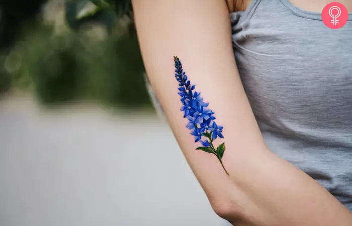 Delphiniums birth flower tattoo on the arm
