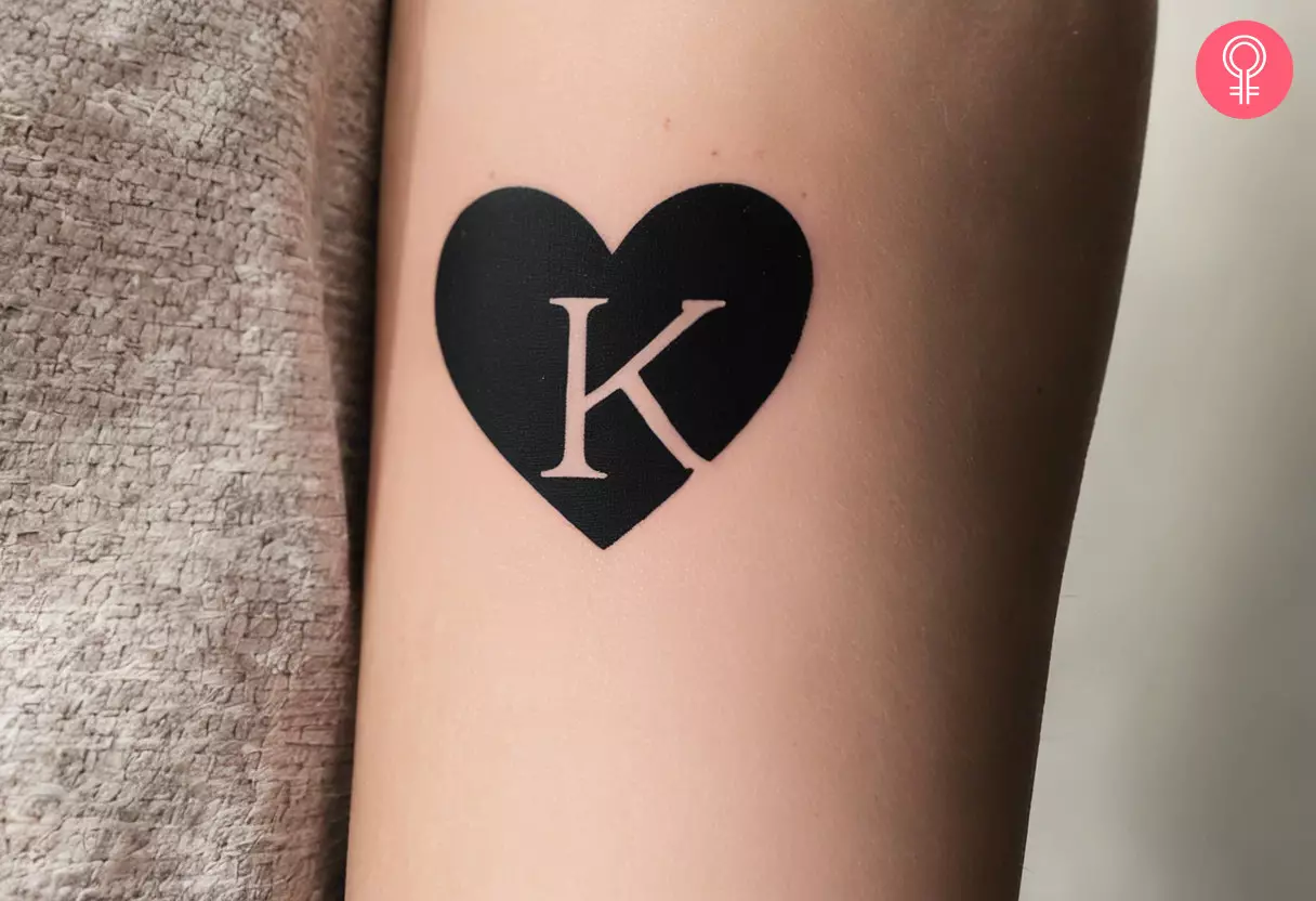 Letter K inside a black heart tattoo