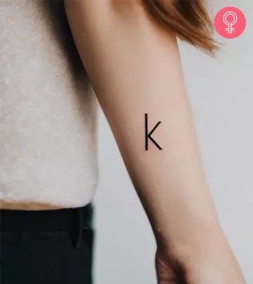 A woman with a T letter tattoo on the upper arm