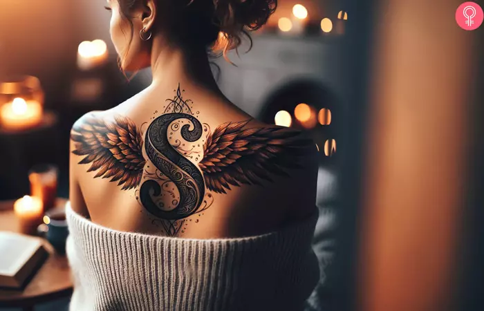 woman with Letter S With Wings Tattoo on her upper back