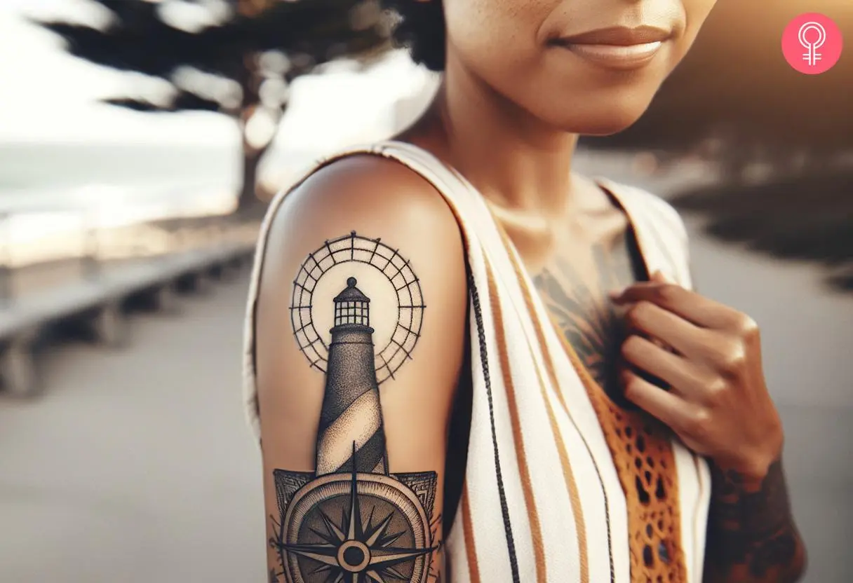 A beautiful lighthouse and compass tattoo on a woman’s upper arm