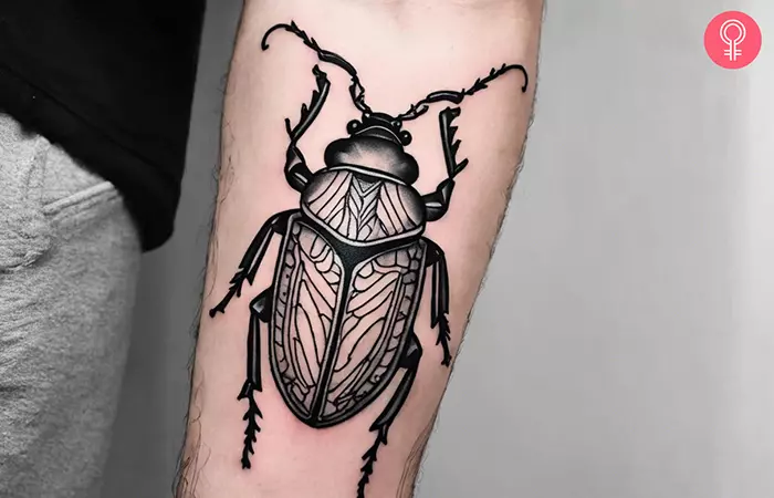 Linework beetle tattoo on the forearm