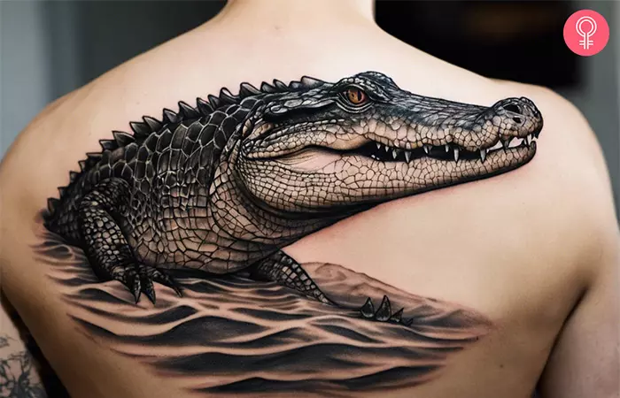 Man with a saltwater crocodile tattoo on the upper back