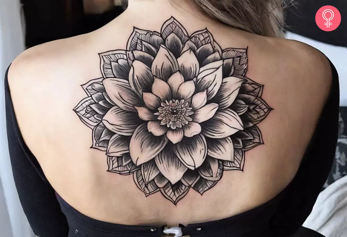A woman wearing a mandala water lily tattoo on her back