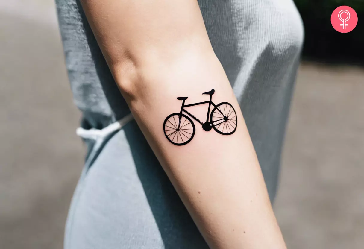 A minimalist bicycle tattoo on the arm