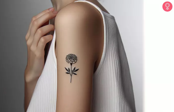 A minimalist marigold tattoo on the upper arm