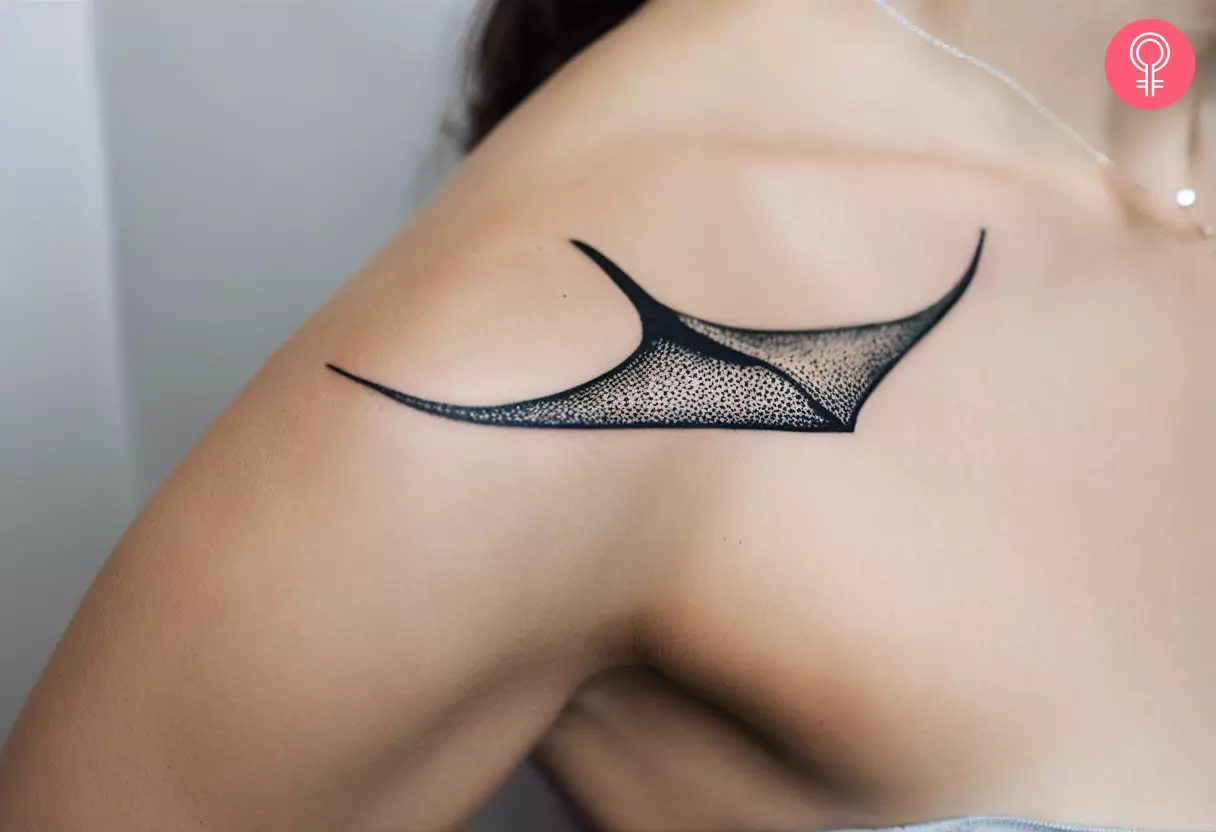 A minimalist stingray tattoo on the shoulder