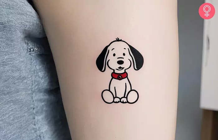 Minimalist Snoopy tattoo on the upper arm