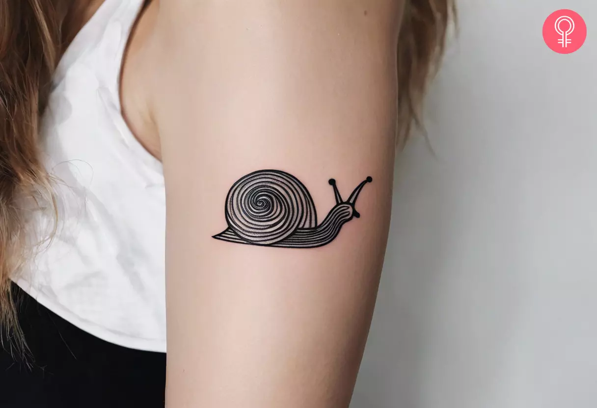 Minimalist snail tattoo on the upper arm