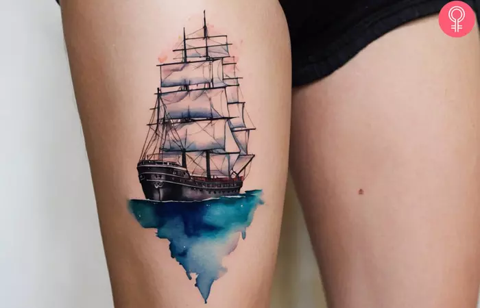 A woman showing a nautical ship tattoo on her thigh