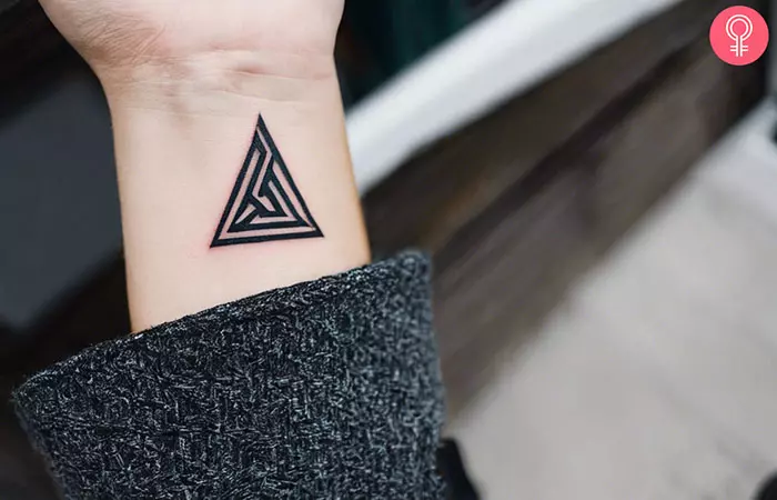 A woman with an Odin Valknut wrist tattoo