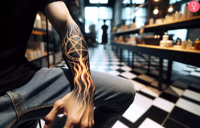 A pentagram with a flame tattoo on the forearm