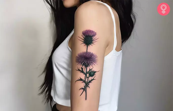 Purple thistle tattoo on the upper arm