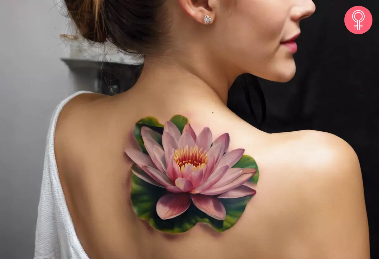A woman flaunting a realistic water lily tattoo on her shoulder blade