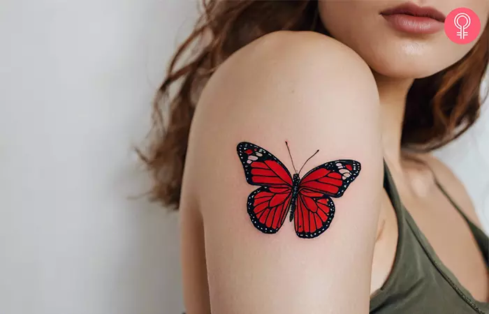 A woman with a red butterfly tattoo on her arm