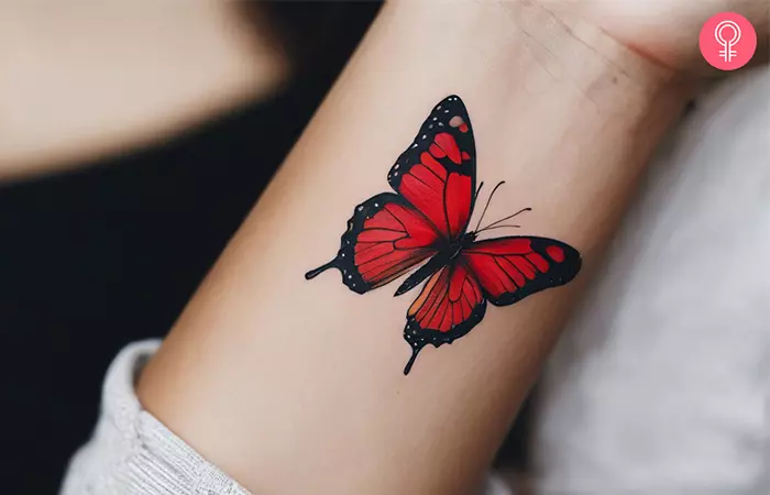 A woman with a red butterfly tattoo on her wrist