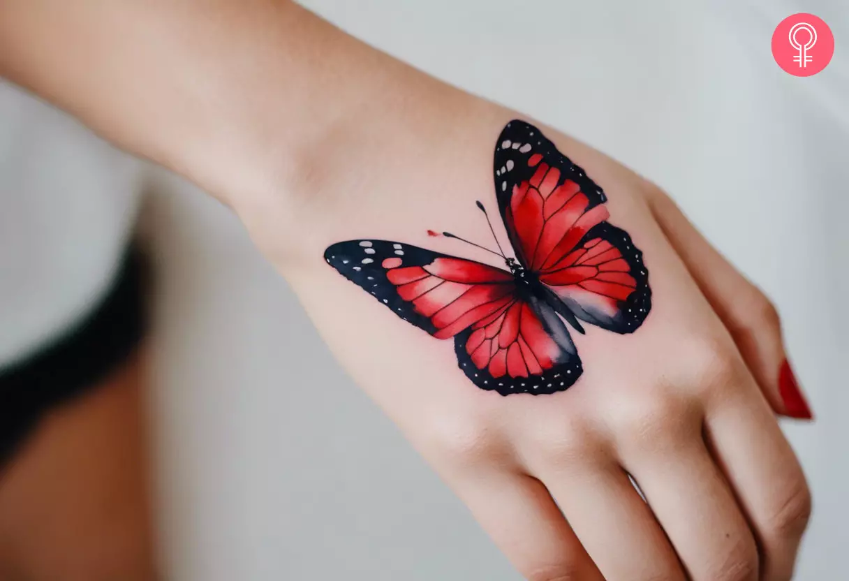 Red butterfly tattoo on the back of the palm