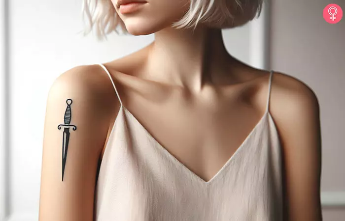 A woman with a simple dagger tattoo on her upper arm