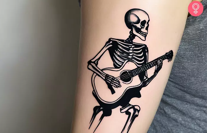 Skeleton playing guitar tattoo 