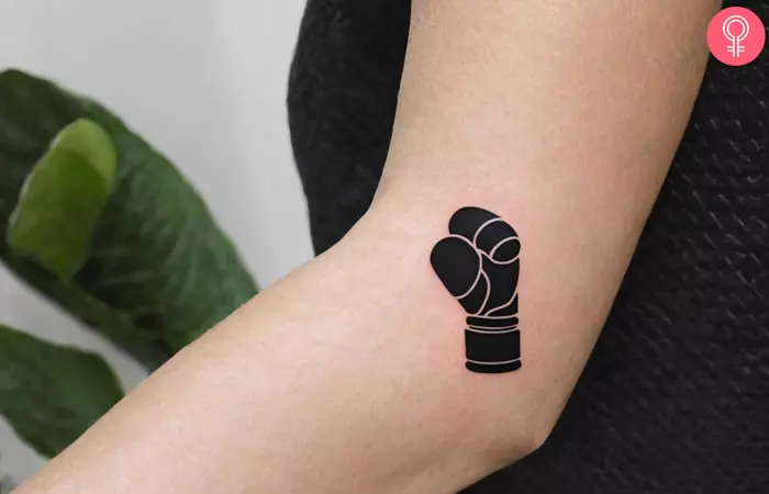 Woman with a small boxing tattoo on her arm