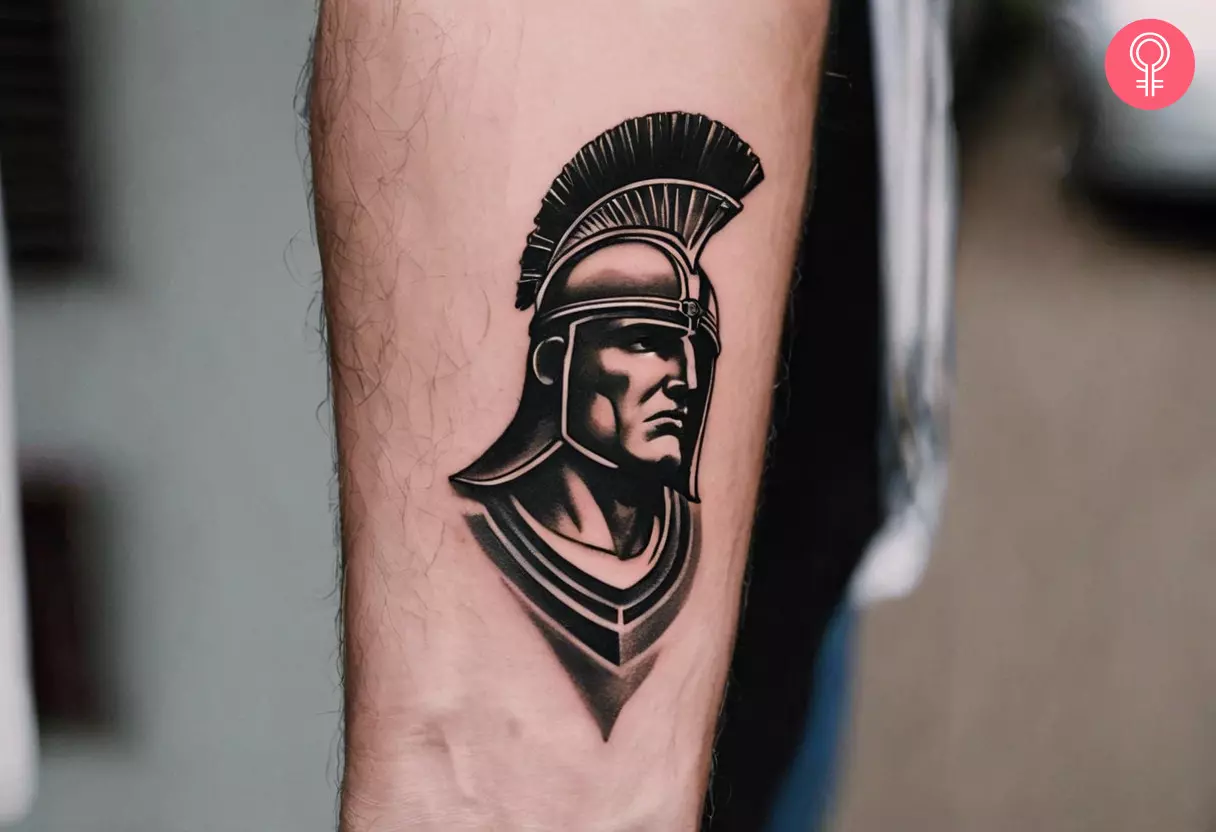 Small tattoo of a gladiator with a helmet on the upper arm