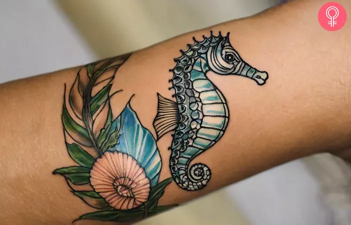 A woman with a small seahorse tattoo on her arm