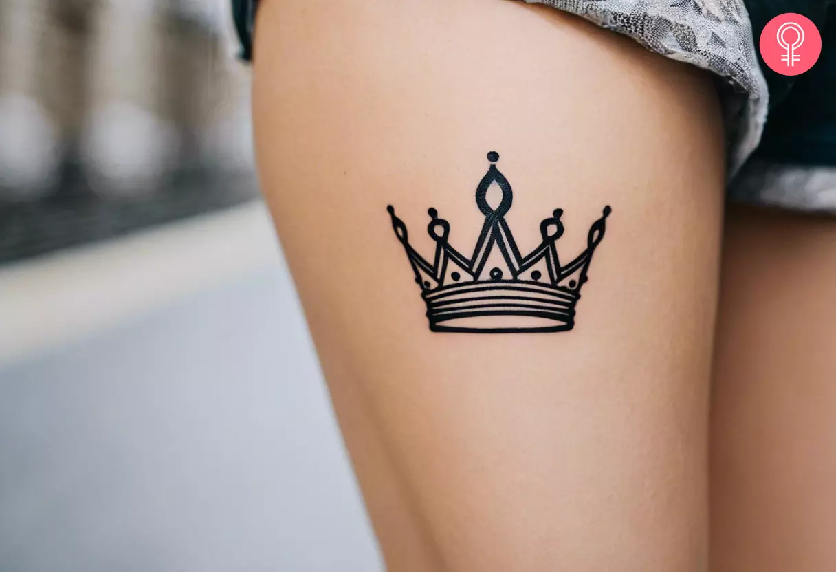 Small crown tattoo on a woman’s thigh