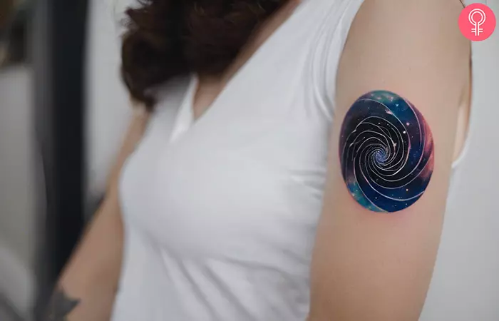Spiral galaxy tattoo on her outer arm