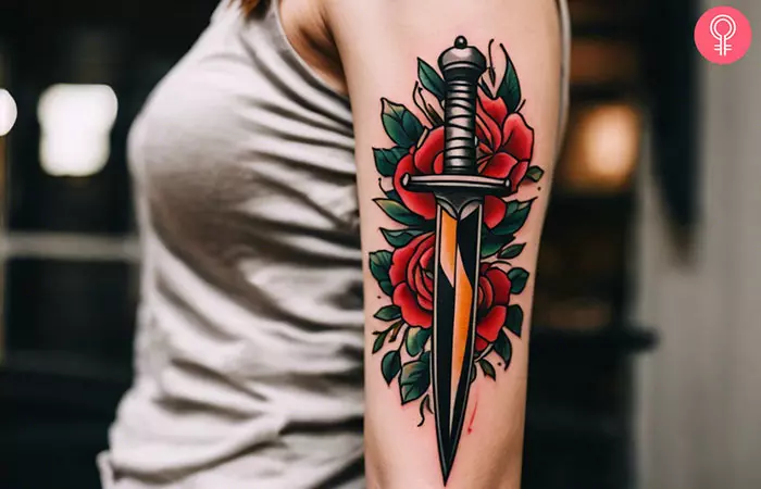 A woman with a traditional dagger tattoo on her upper arm