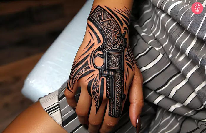 Tribal gun tattoo on the hand