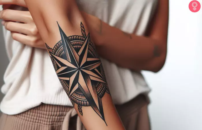 A woman showing a tribal nautical star tattoo on her forearm