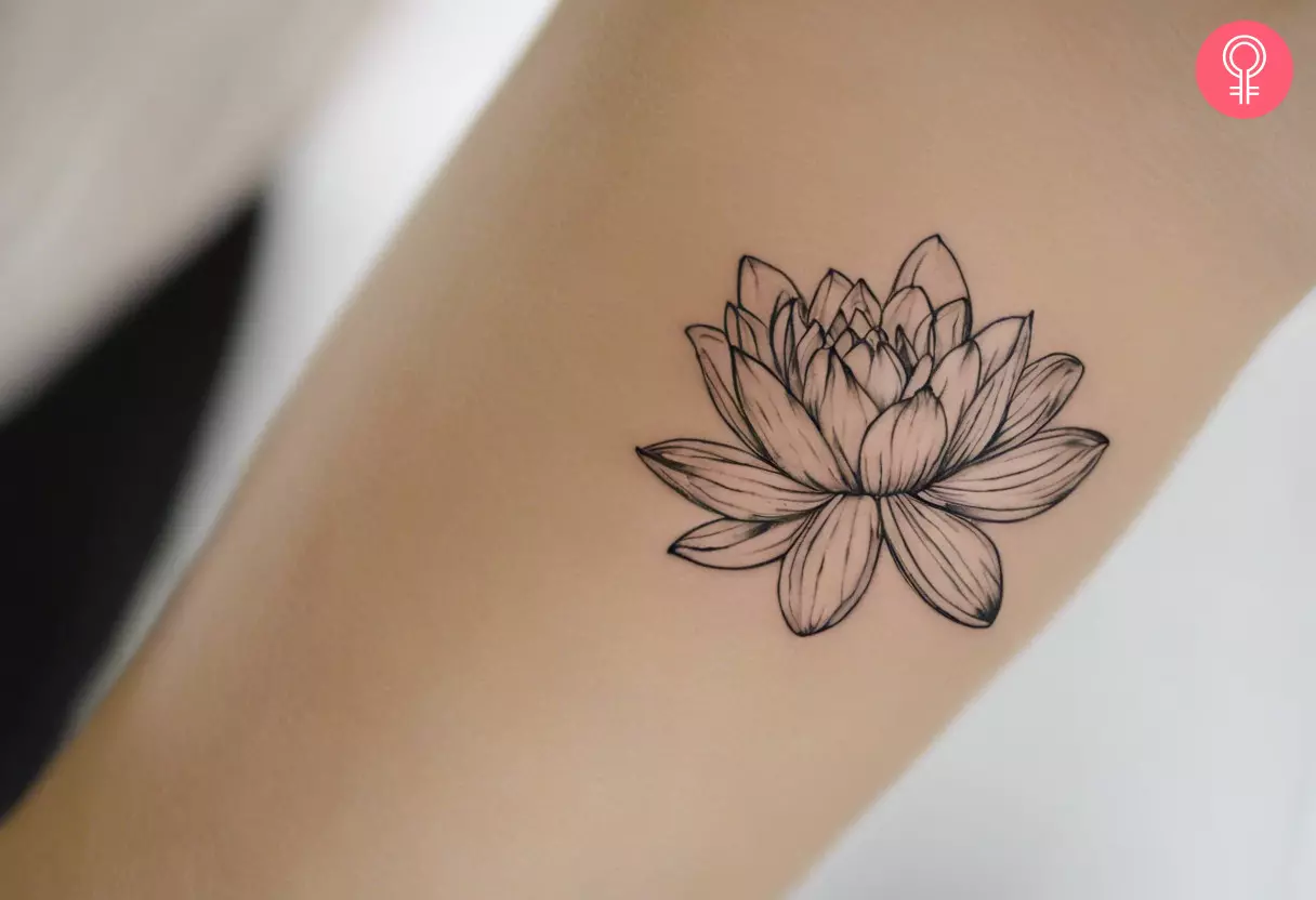 A woman wearing a water lily tattoo on her forearm