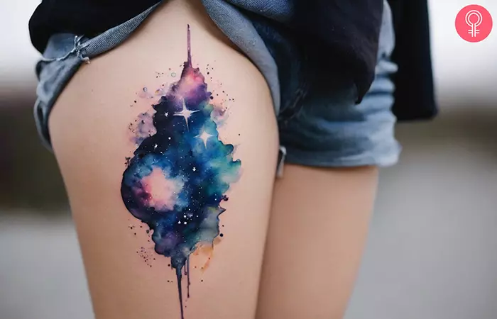 Watercolor galaxy tattoo on the thigh